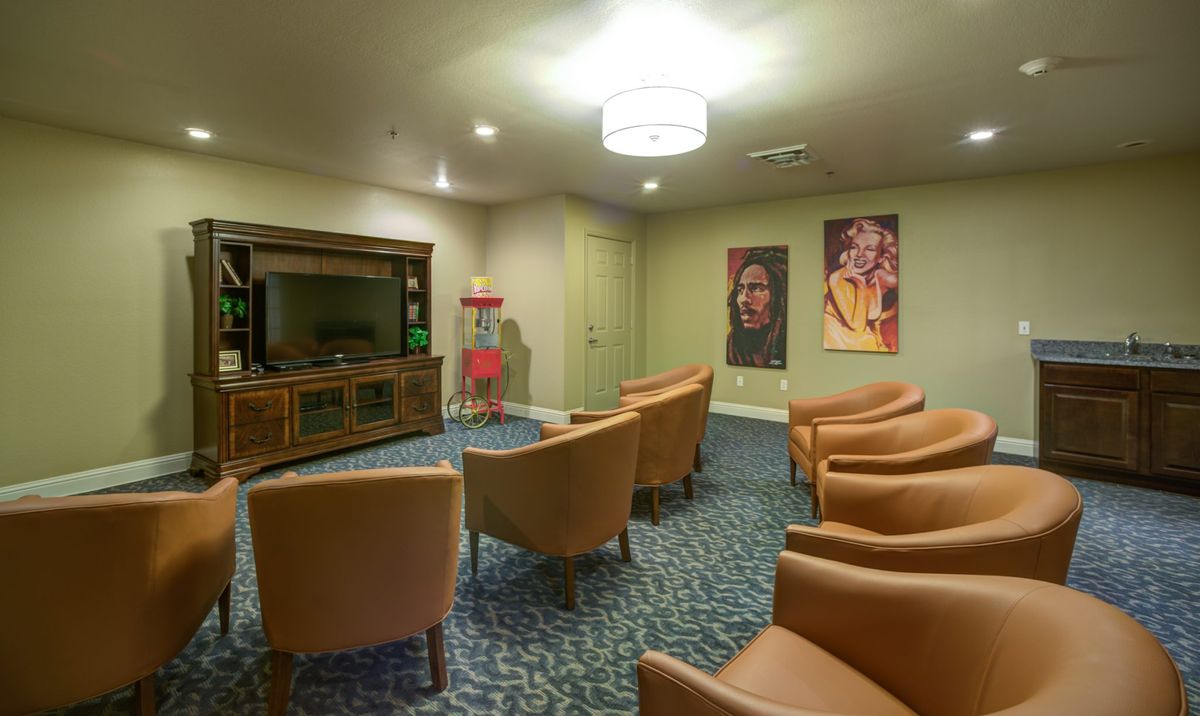 A cozy seating area with a television and decorative posters on the wall.