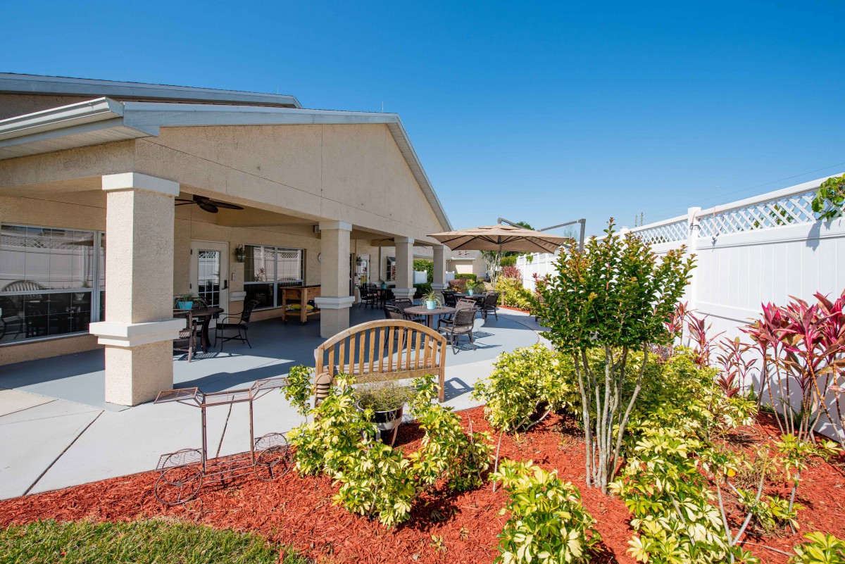 A beautifully landscaped backyard with a covered patio and comfortable outdoor seating.