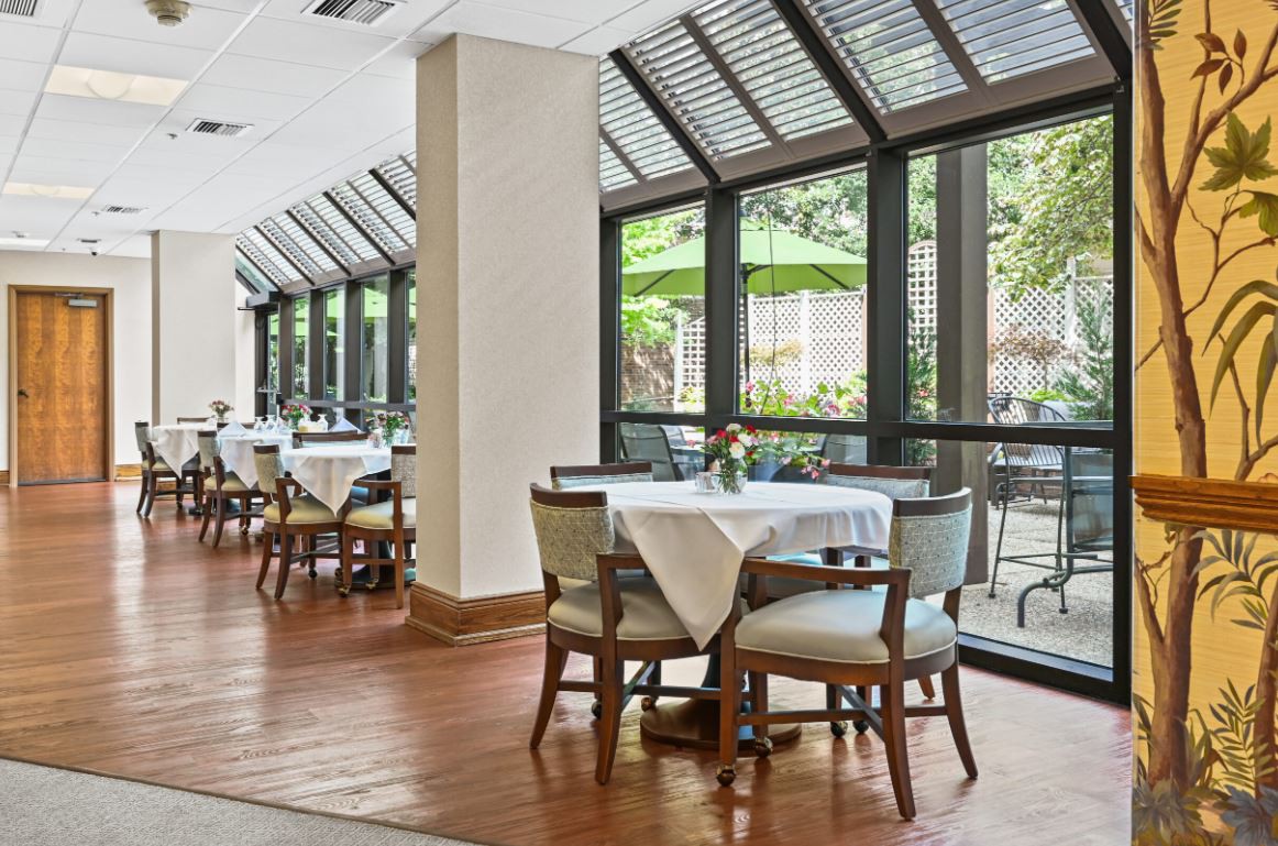 A bright and inviting restaurant interior with neatly arranged tables and chairs near large windows.