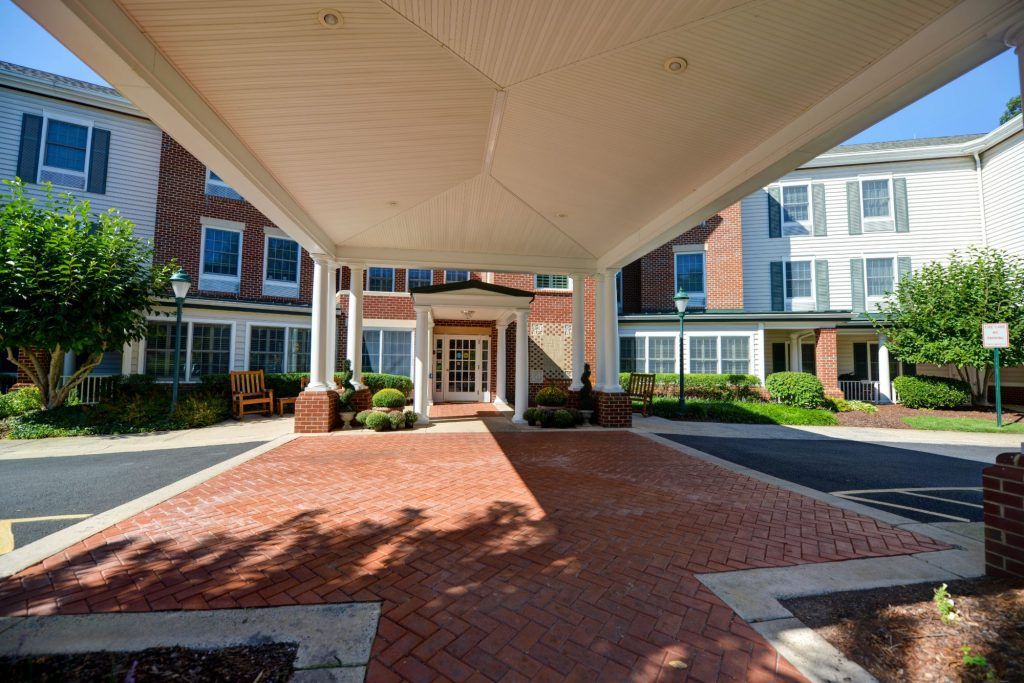 A building entrance with a covered walkway and landscaped surroundings.