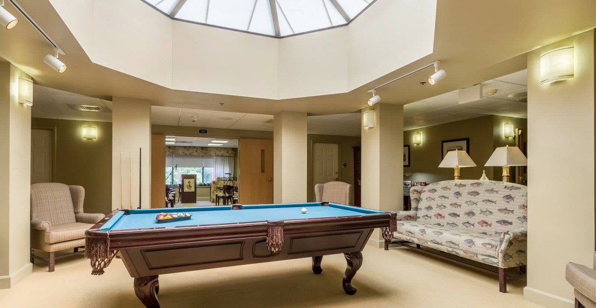A luxurious billiard room featuring a pool table under a skylight.