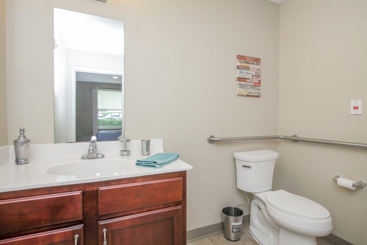 A well-organized bathroom with a sink, mirror, and toilet.