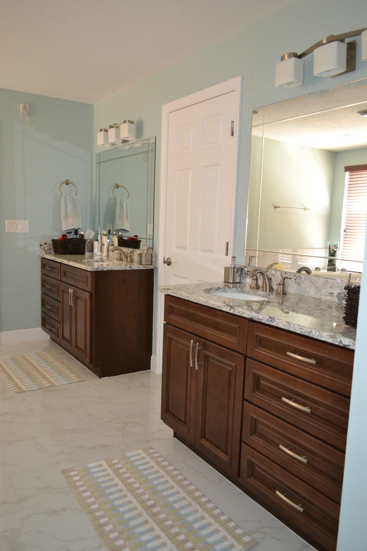 A modern bathroom with double sinks and wooden cabinets.