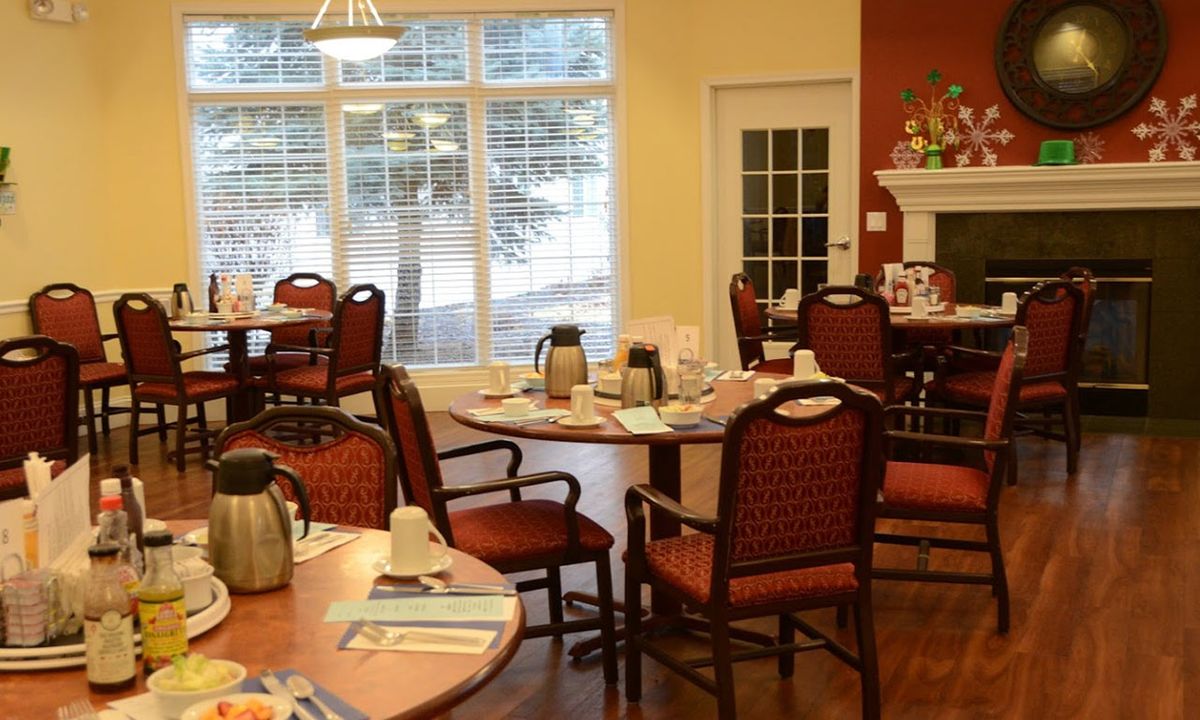 A cozy dining room with neatly arranged tables and chairs, set for a meal.