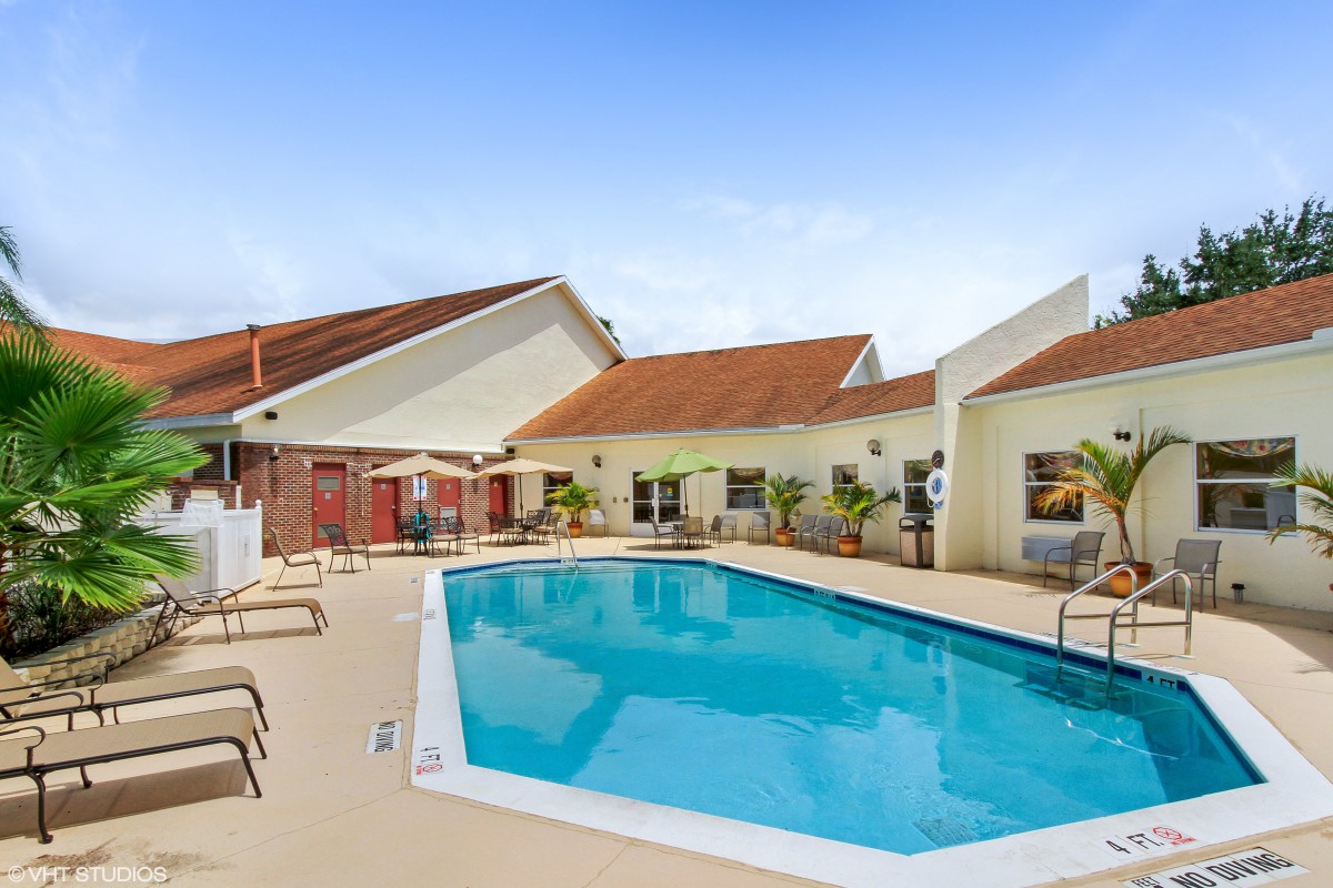 A tranquil outdoor swimming pool area with lounge chairs.