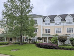 A view of a residential building surrounded by lush landscaping.