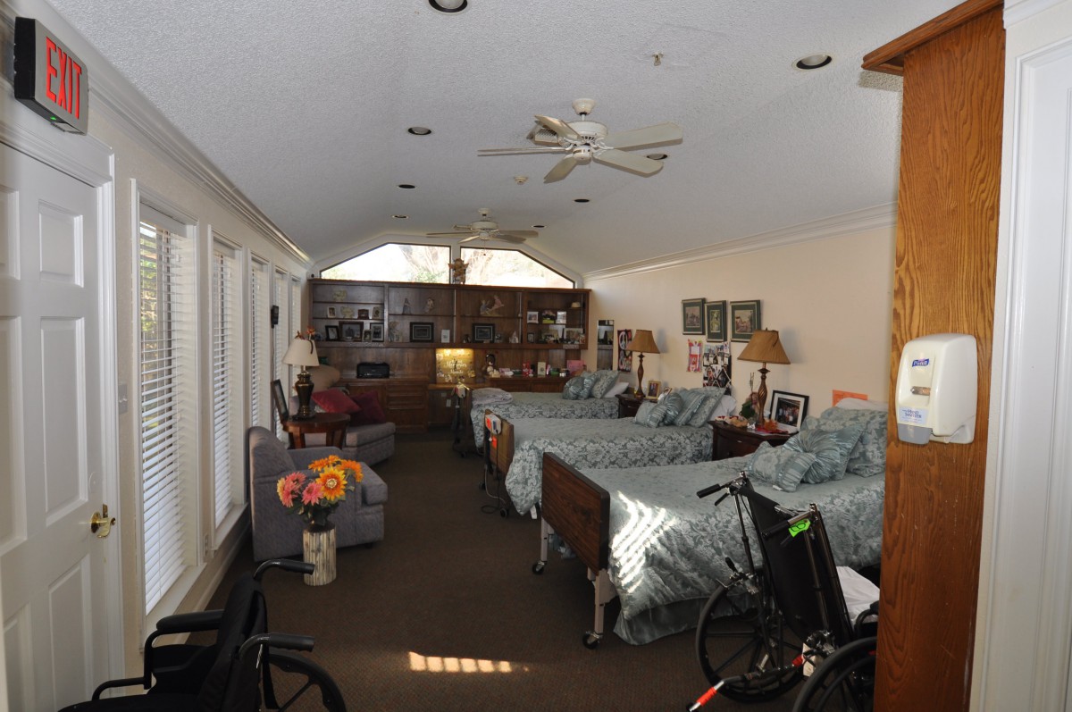 A spacious bedroom with multiple beds, cozy decor, and a wheelchair-accessible setup.