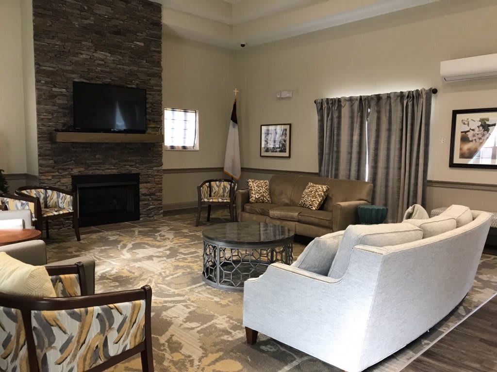 A cozy living room with comfortable seating, featuring a fireplace and television.
