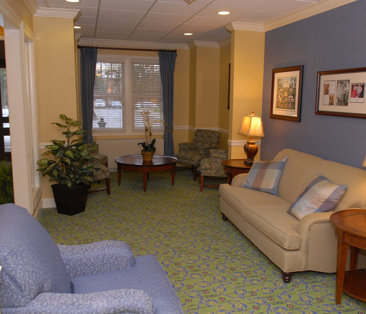A cozy living room with sofas, chairs, a lamp, and decorative elements.