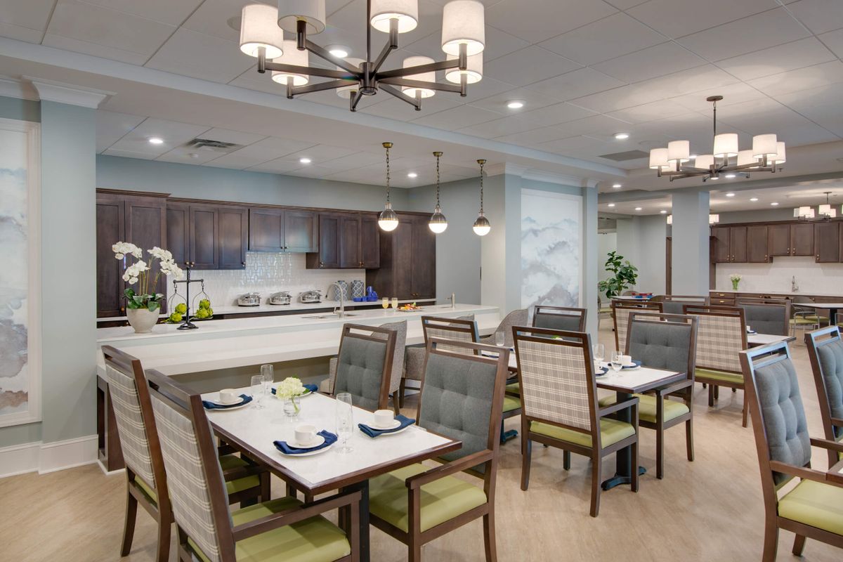 A modern dining room with neatly arranged tables and elegant lighting fixtures.