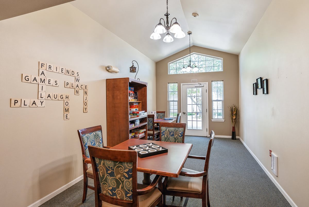 A cozy meeting room with a wooden table, chairs, and a bookshelf against the wall.