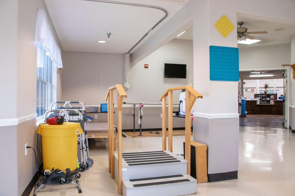A physical therapy room featuring equipment used for rehabilitation exercises, including a set of practice stairs.