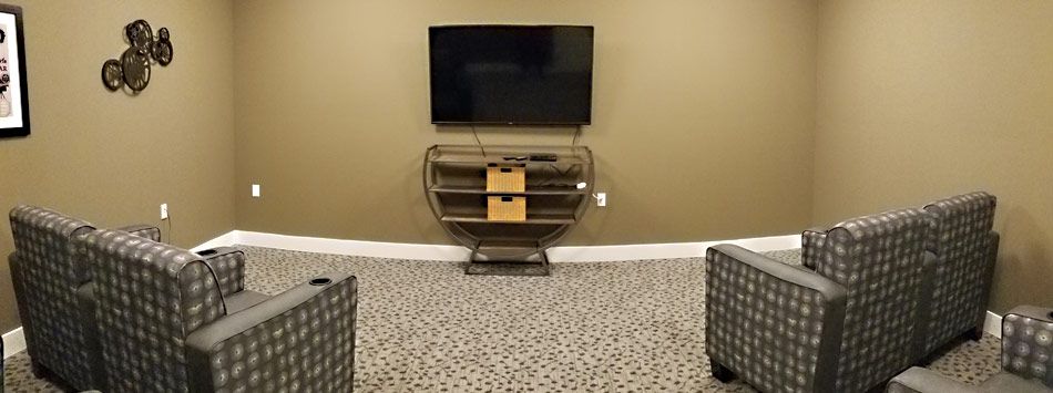 A minimalist living room setup with a mounted television and a small entertainment center.