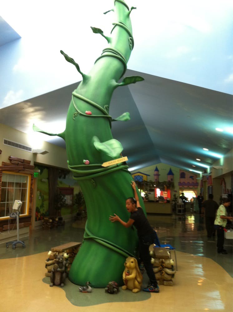 A whimsical beanstalk decoration inside a shopping mall.
