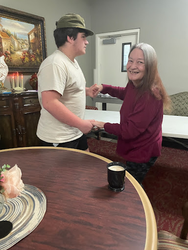 A joyful moment between two people sharing a dance or dance-like interaction indoors.