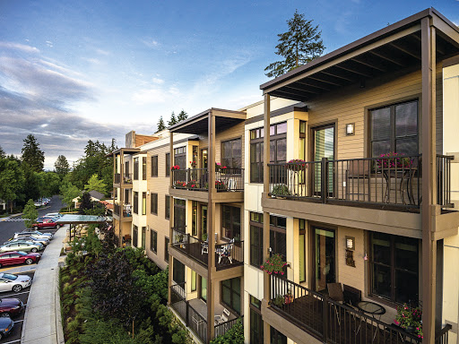 A modern apartment complex featuring spacious balconies and lush landscaping.