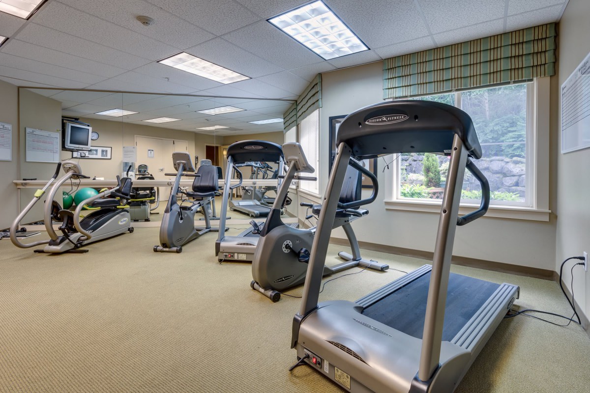 A well-equipped gym with multiple treadmills and exercise machines.