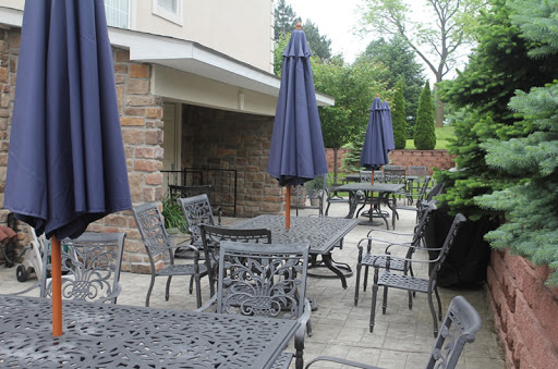 A serene outdoor patio area featuring tables and chairs with umbrellas for shade.