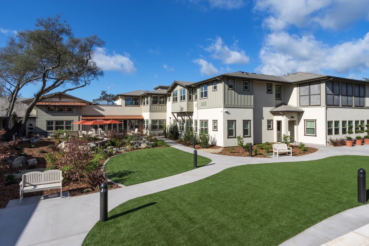 A modern residential building with a well-maintained garden and pathways.