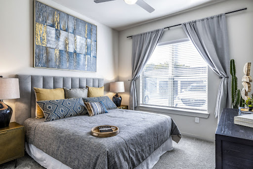 A modern and cozy bedroom featuring a stylish gray color scheme, comfortable furnishings, and artistic accents.