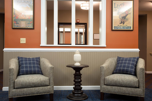 A cozy living room setup featuring two comfortable chairs, a decorative table, and warm-colored walls.