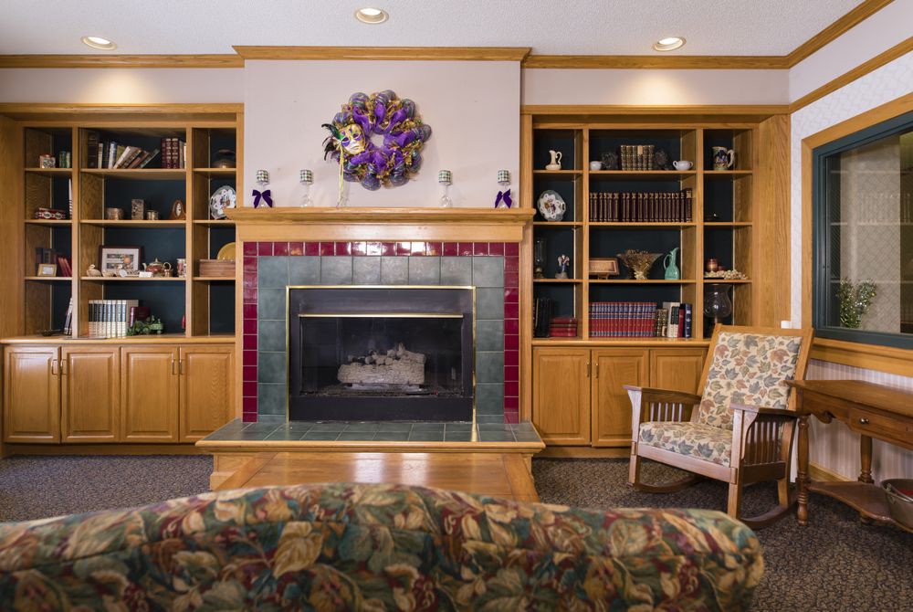 A cozy living room with a central fireplace flanked by built-in bookshelves and a comfortable chair.