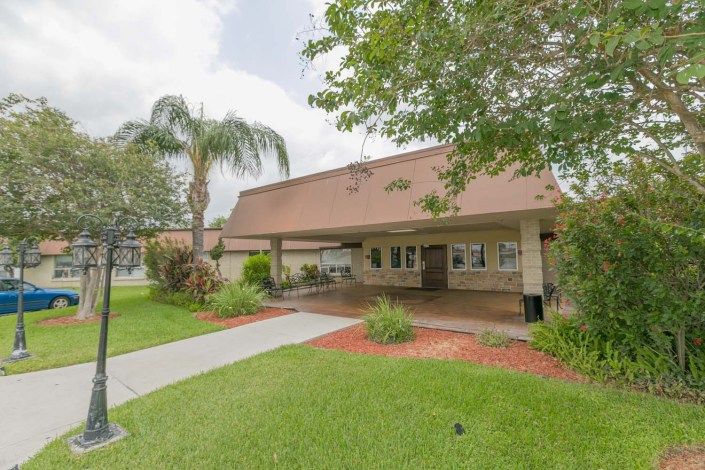 A residential building with a landscaped entrance and palm trees.