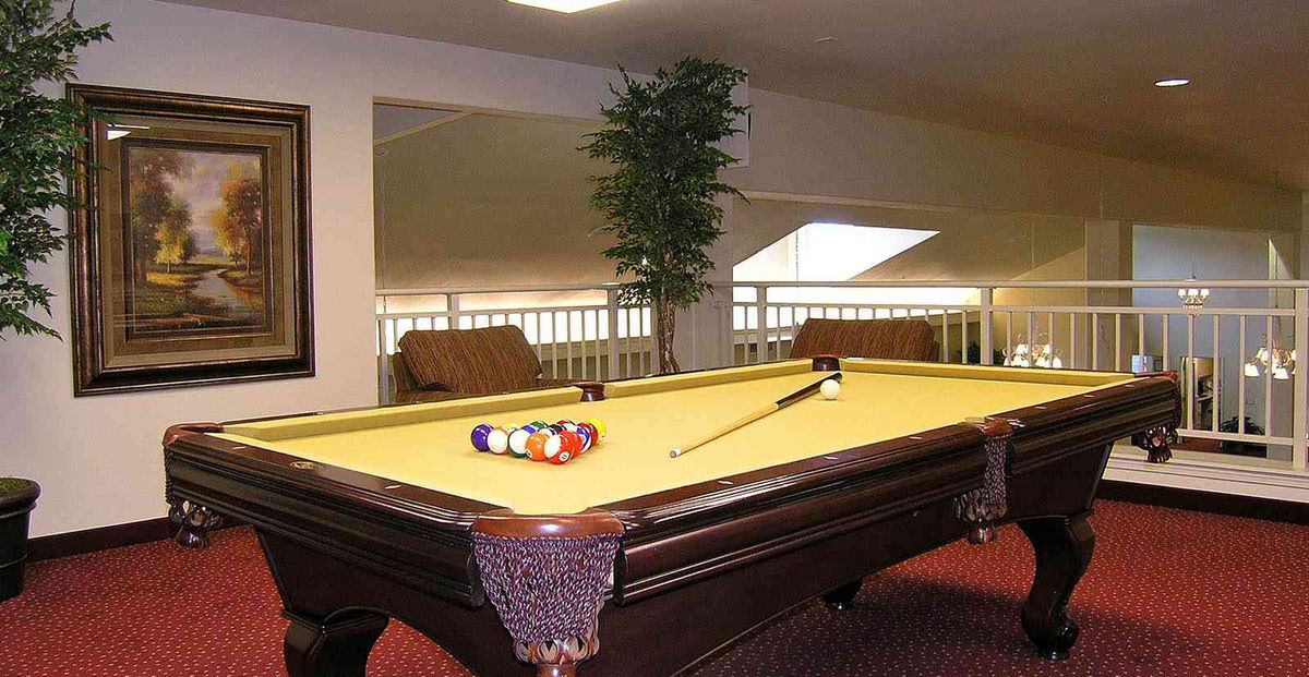 A pool table set up for a game in a well-lit indoor recreational area.