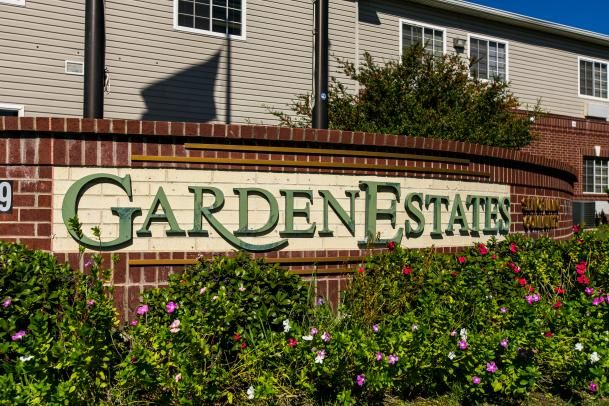 Entrance sign for Garden Estates surrounded by flowers.