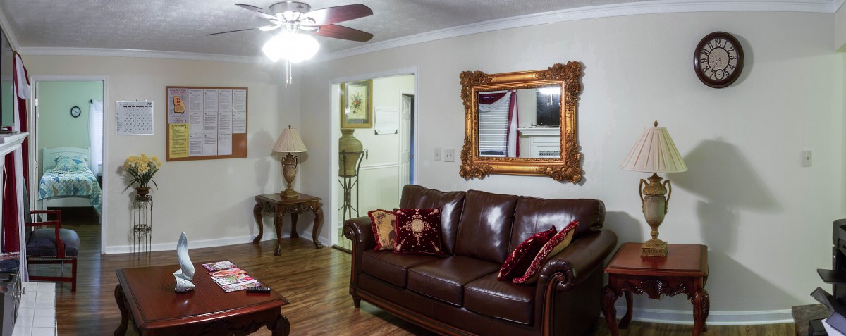 A cozy living room featuring a leather sofa, ornate mirror, and warm lighting.