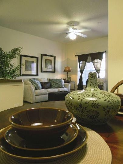 A cozy living room with elegant decor, featuring a stylish couch, artwork on the walls, and a decorative vase on the table.