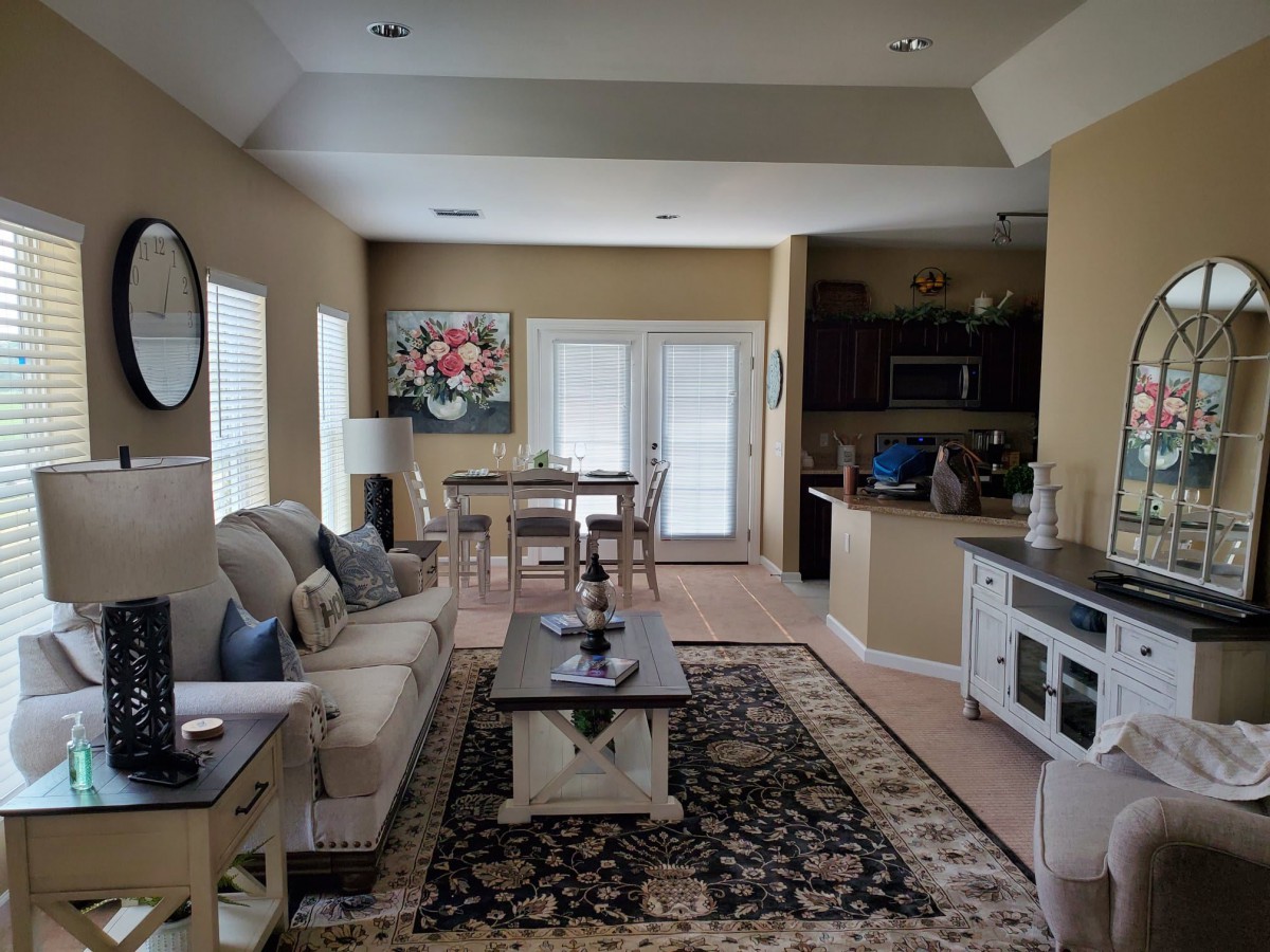 A cozy living space with an open layout, featuring a sofa, dining area, and kitchen.