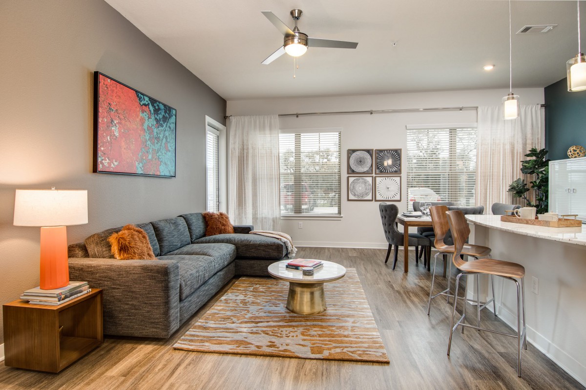 A modern living room with a comfortable sofa, stylish coffee table, and vibrant artwork, seamlessly connecting to a dining area.