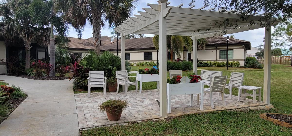 A tranquil outdoor seating area with a pergola and potted plants.