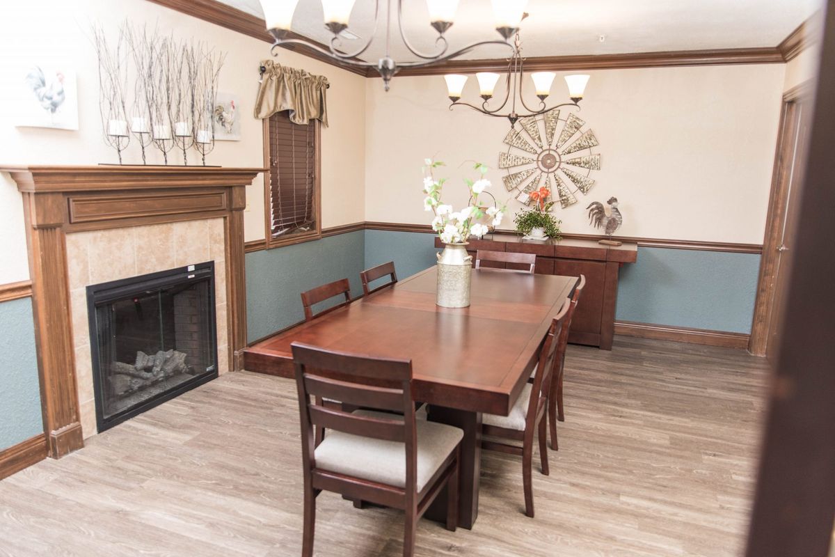 A cozy dining room with a wooden table, elegant chandelier, and tasteful decor.
