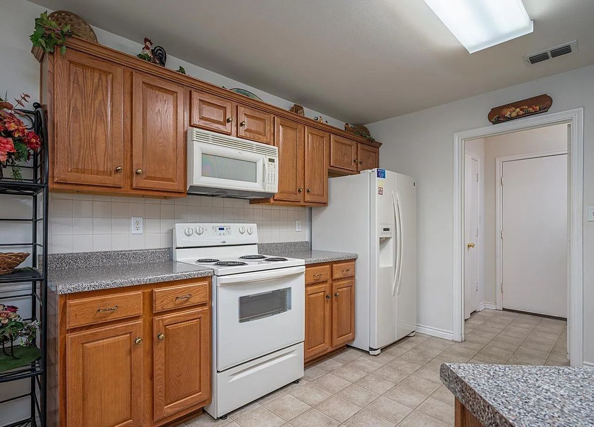 A modern kitchen with wooden cabinets and standard appliances.