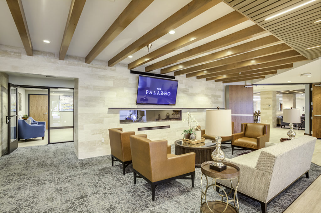 A modern lounge area featuring comfortable seating and a wall-mounted television.