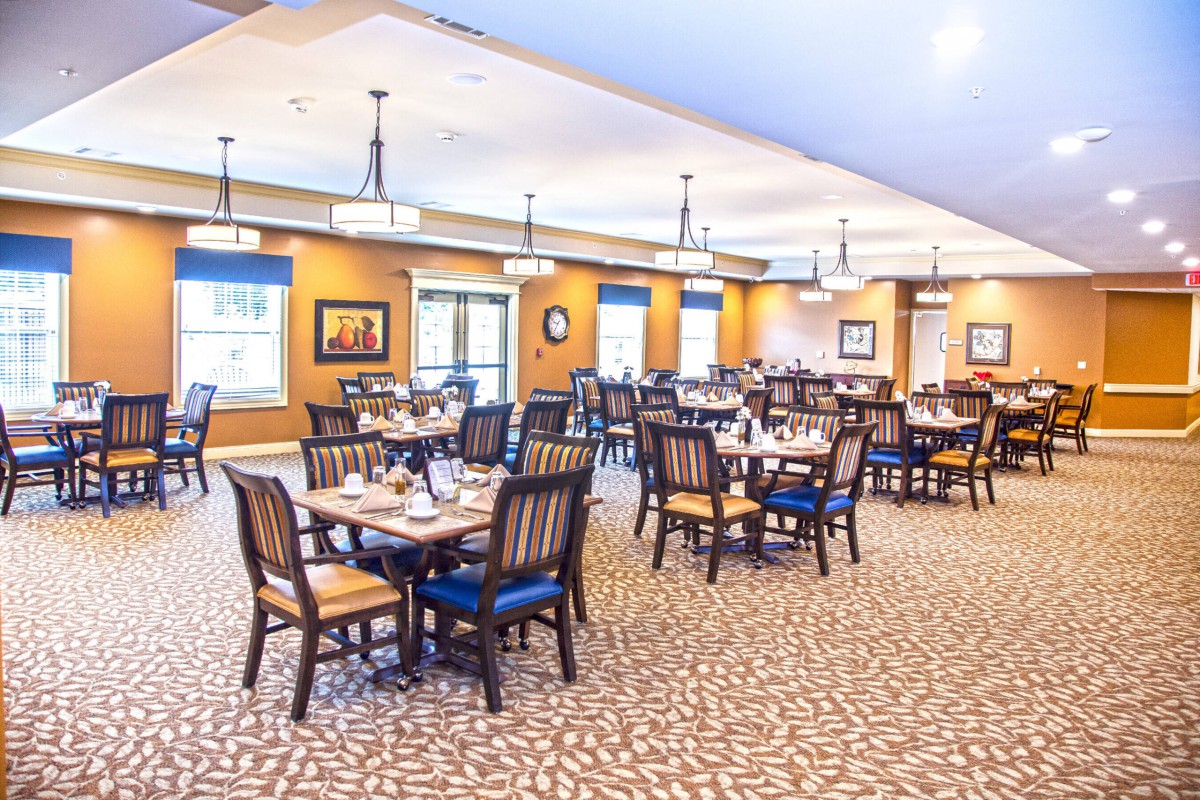 A spacious and well-lit dining area with neatly arranged tables and chairs.