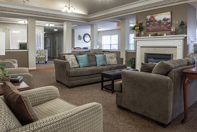A cozy living room with sofas, armchairs, and a fireplace.