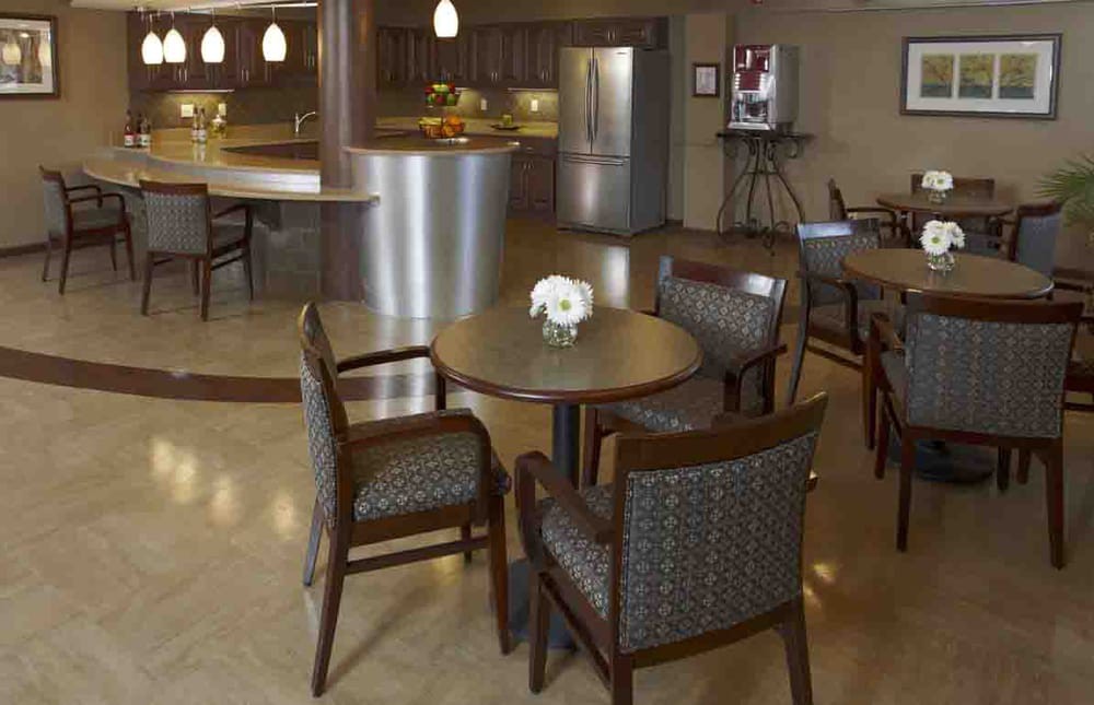 A modern kitchen and dining area with a round table, chairs, and a stainless steel refrigerator.
