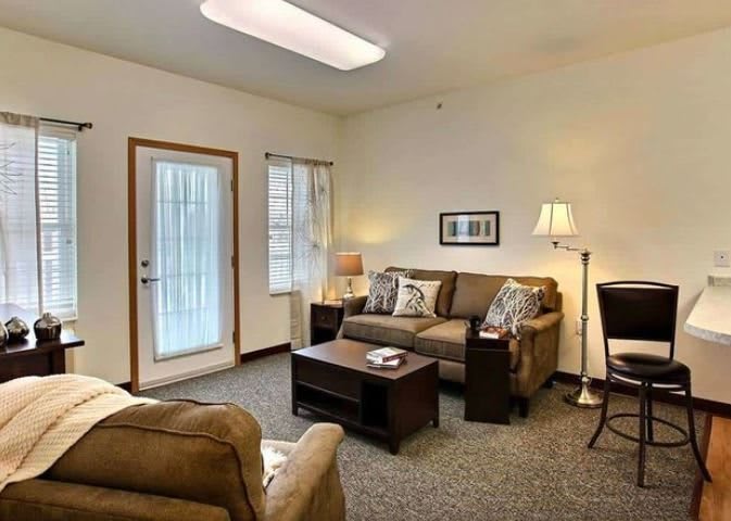 Cozy living room with sofas and a coffee table under warm lighting.