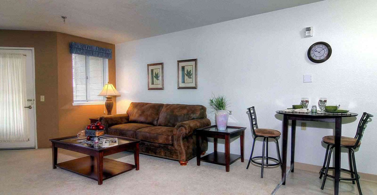 A cozy living room with a sofa, coffee table, and wall decor.