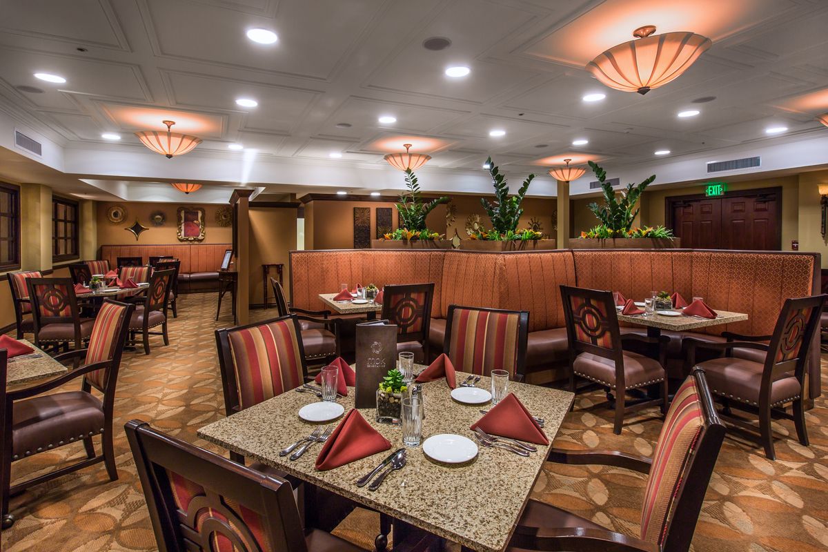 A cozy restaurant dining area with elegantly set tables and warm lighting.