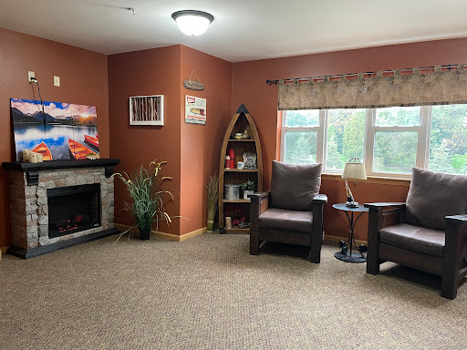 A cozy living room featuring comfortable chairs, a fireplace, and decorative elements.