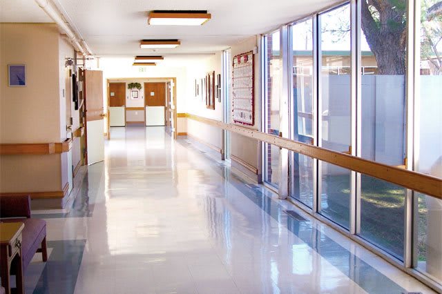 A bright and clean hospital corridor with large windows.
