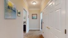 A well-lit hallway with artwork and adjacent rooms.