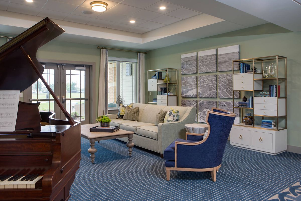 A stylish living room featuring a grand piano, cozy seating, and elegant decor.
