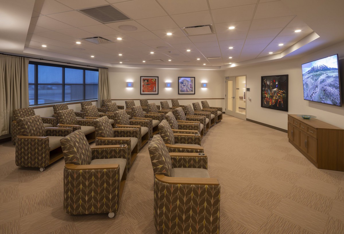 A modern waiting room with patterned chairs and artwork on the walls.