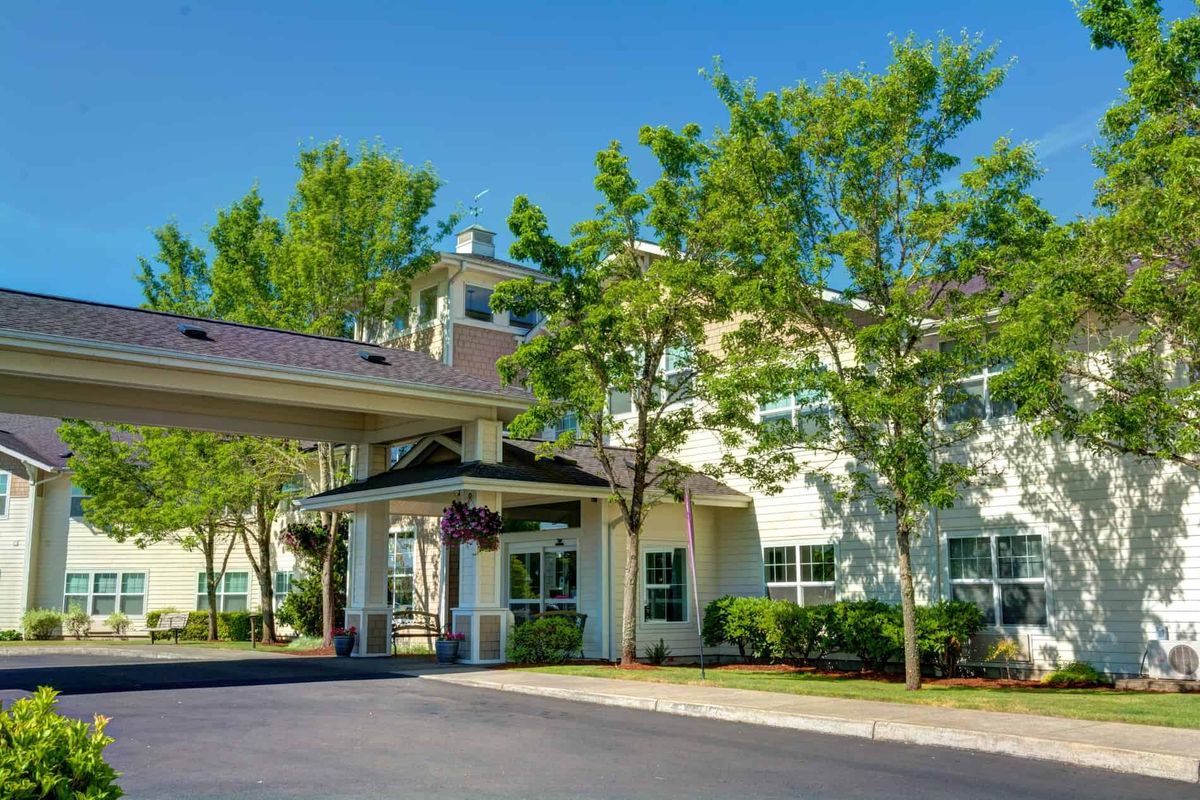 Front view of a hotel with a welcoming entrance and surrounding trees.