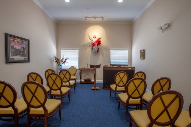 Interior view of a small chapel with arranged seating and an altar.